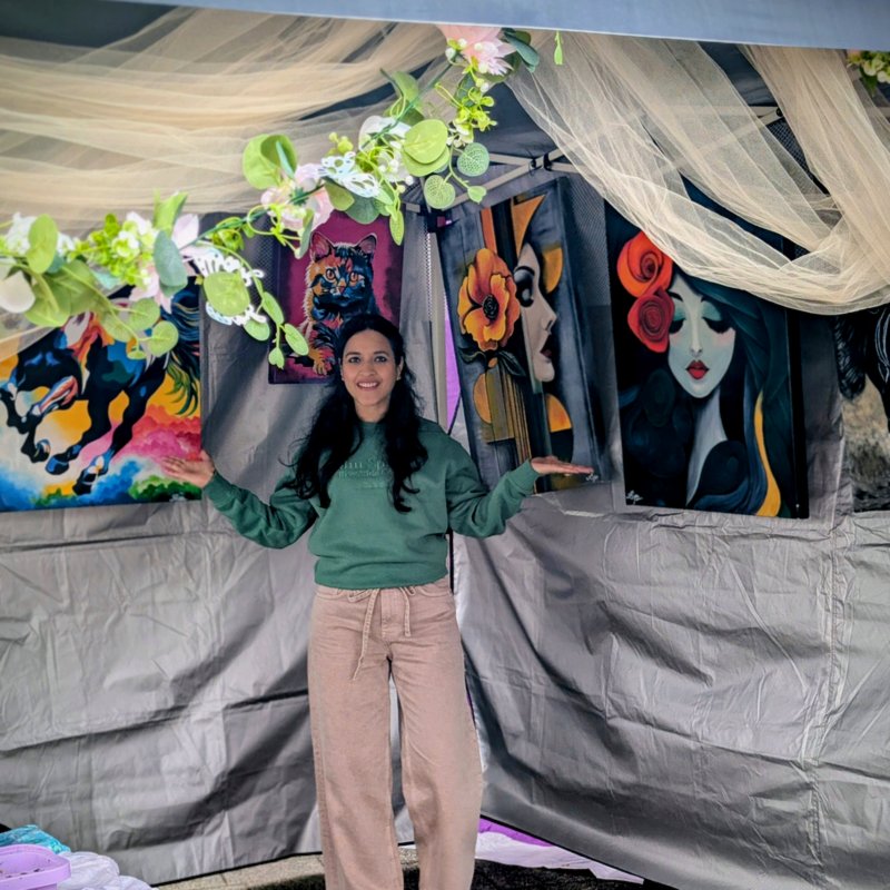 Shilpi Jain at her decorated art stall displaying original acrylic paintings