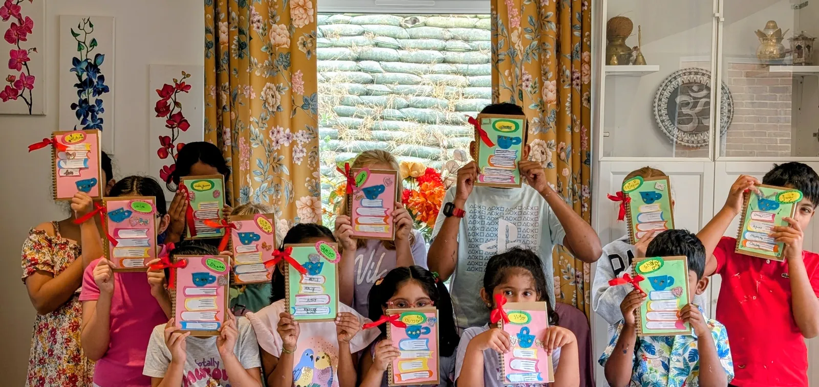 A group of children holding up the personalised storybook covers they designed